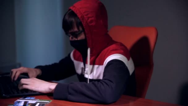 L'hacker maschile lavora su un computer con dati sugli schermi in una stanza buia . — Video Stock