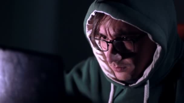 Чоловічий хакер працює на комп'ютері з даними на екранах у темній кімнаті . — стокове відео