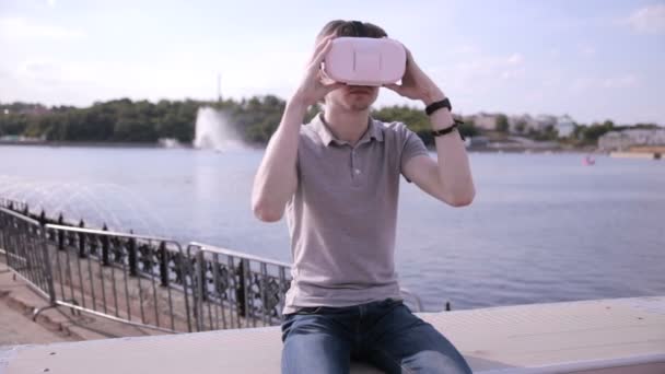 Junger Mann trägt Virtual-Reality-Brille im Freien. — Stockvideo