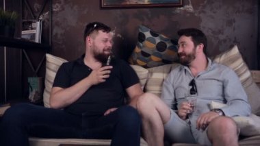 Sigara e-sigara vape konuşurken ve vaping kafede oturan iki şık genç adam.