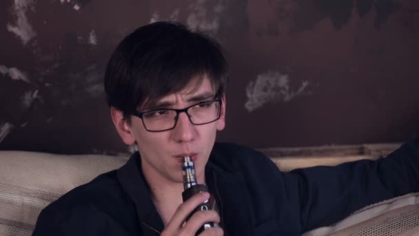 Young man smoking electronic vape. Vaping in cafe. — Stock Video