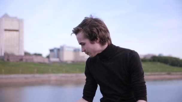 A fiatalember szerzés üzenet a táblaszámítógépre, a városi tó közelében. — Stock videók