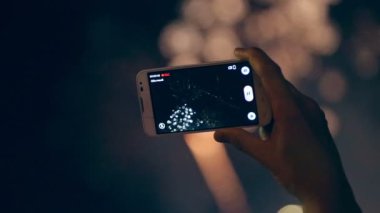 Adam cep telefonu üzerinde renkli havai fişek filme.