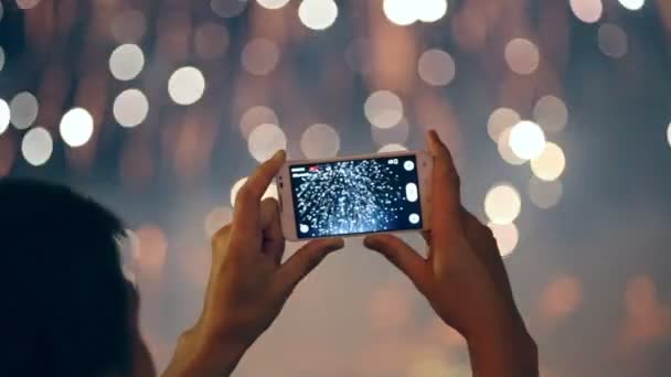 Homme filmant des feux d'artifice colorés sur son téléphone portable . — Video