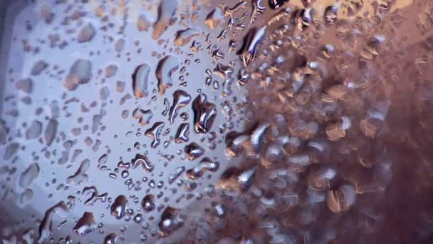 La pluie tombe sur la fenêtre. Feux de circulation bokeh en arrière-plan, pluie descendant la fenêtre . — Video