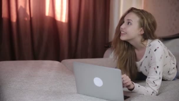 Пара, использующая ноутбук на диване в своем доме . — стоковое видео