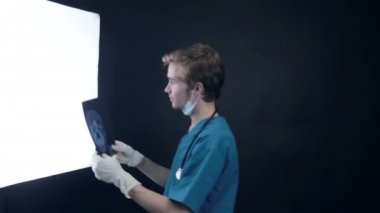 Erkek doktor bir kafa röntgeni görüntüsünü incelenmesi.