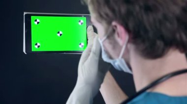 Holding ve dijital tablet yeşil ekran ile tarama erkek doktor.
