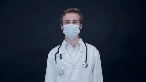 El doctor sonriente quita la máscara médica que mira en la pantalla. Paquete . — Vídeos de Stock