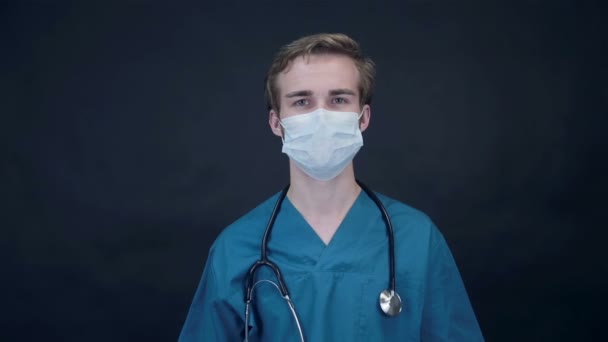 Lächelnder Arzt entfernt medizinische Maske, die in Bildschirm schaut. Packshot. — Stockvideo