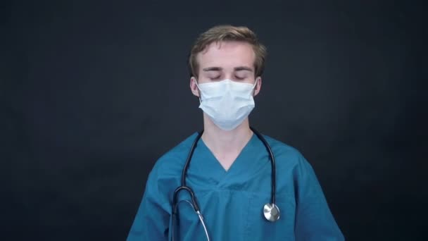 Moody γιατρός αφαιρεί ιατρική μάσκα ψάχνει σε οθόνη. Packshot. — Αρχείο Βίντεο