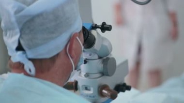 Tanınmayan doktor mikroskobu işlemi sırasında arıyorsunuz.