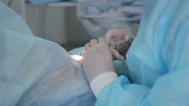 Medici irriconoscibili mani che eseguono interventi chirurgici in sala operatoria ospedaliera . — Video Stock