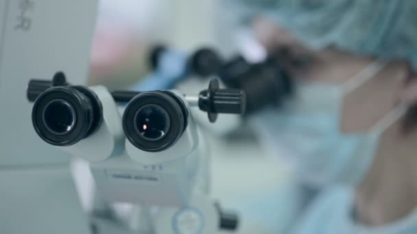 Médecin méconnaissable regardant au microscope pendant le fonctionnement . — Video