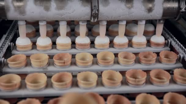 Moving conveyer with ice-cream cones. Filling ice cream in cones, cup. — Stock Video