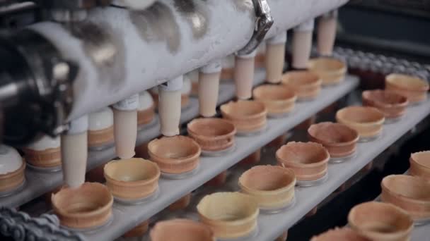 Bewegliches Förderband mit Eistüten. Füllen von Eis in Tütchen, Tasse. — Stockvideo