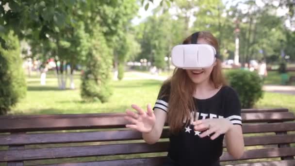 Молодая женщина в шлеме VR с дисплеем крепления головы. На открытом воздухе . — стоковое видео