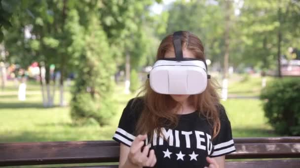 Young woman using VR helmet with head mount display. Outdoors. — Stock Video