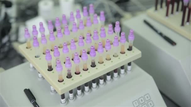 Сучасна медична автоматизована машина оглядає пробірку з зразками крові в медичній лабораторії . — стокове відео