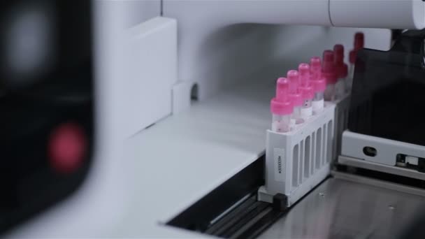 Moderno analizador automático de hematología médica. Tubos de ensayo en transportador robótico . — Vídeos de Stock