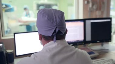 Tanınmayan doktor kontrolleri işlemi hastane ameliyathane bilgisayar ekranlarında performans.