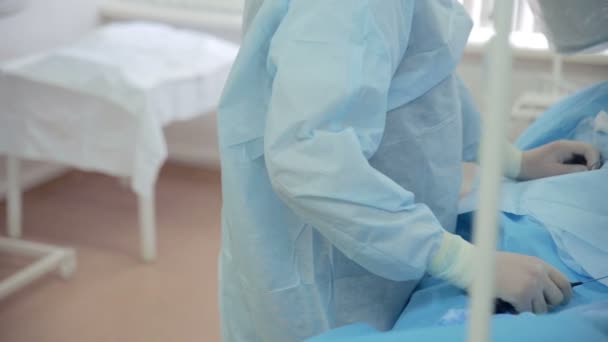 Unrecognizable Surgeons hands performing operation in hospital operating room. Surgeon operating patient. — Stock Video