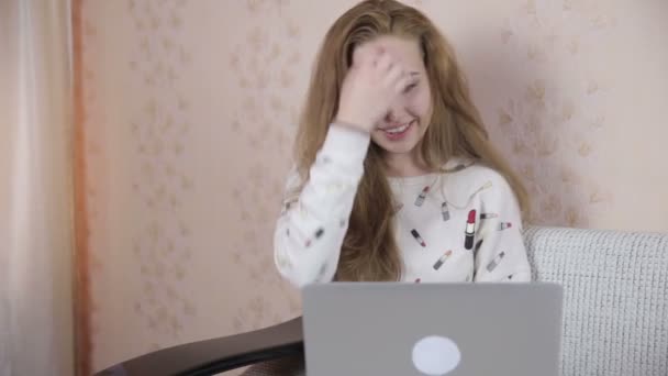 Усміхаючись, красива, мила дівчина використовує ноутбук . — стокове відео