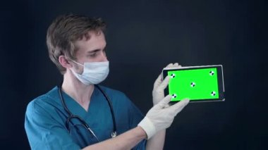 X-ışını ile çalışan profesyonel doktor inceden inceye gözden geçirmek ve yeşil ekran ile tablet.