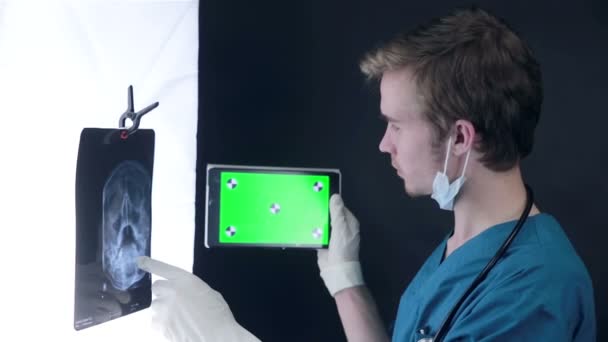 X 線を扱う専門の医者をスキャンし、緑のスクリーンを搭載したタブレット. — ストック動画