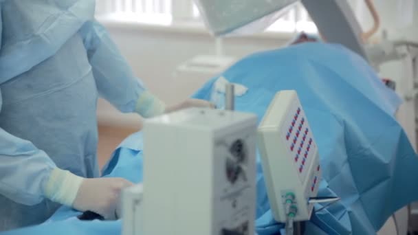 Неузнаваемые хирурги делают операцию в операционной больницы. Операционный пациент . — стоковое видео