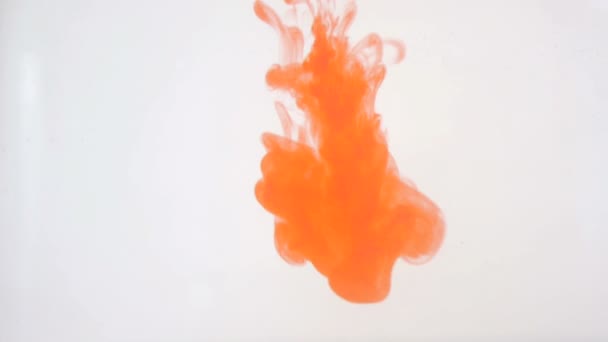 Heller, bunter Hintergrund. Farbmischung mit orangefarbener Flüssigtinte in Wasser. — Stockvideo