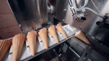 Gıda fabrikasında modern ekipmanlar. Otomatik konveyör, dondurma külahlarının üretim hattı.