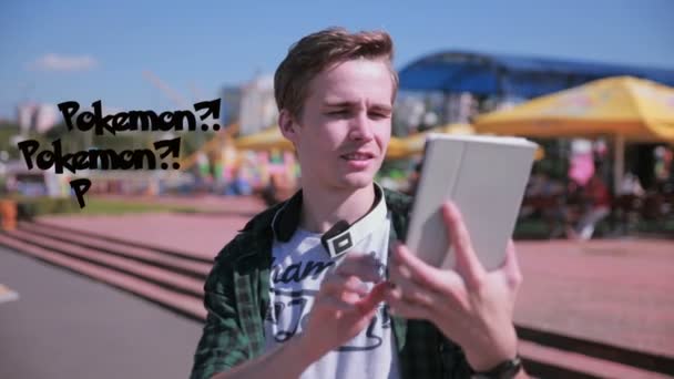 Unga hipster man använder tablet i staden spelar pokemon gå. — Stockvideo