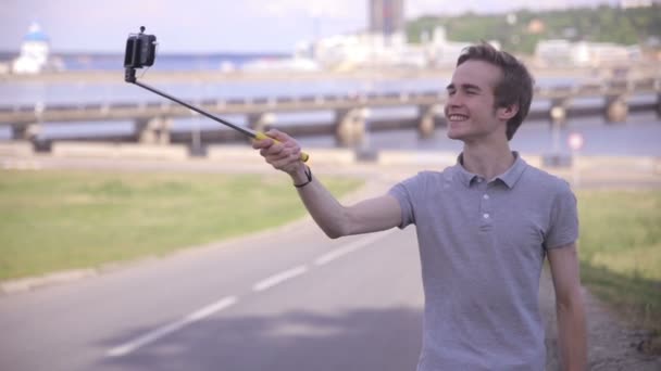 El hombre se hace selfie en la ciudad, paisaje urbano . — Vídeos de Stock