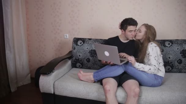 Casal jovem compartilhando um laptop dentro de casa . — Vídeo de Stock
