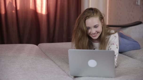 Joven alegre, linda chica usando el ordenador portátil de interior . — Vídeos de Stock