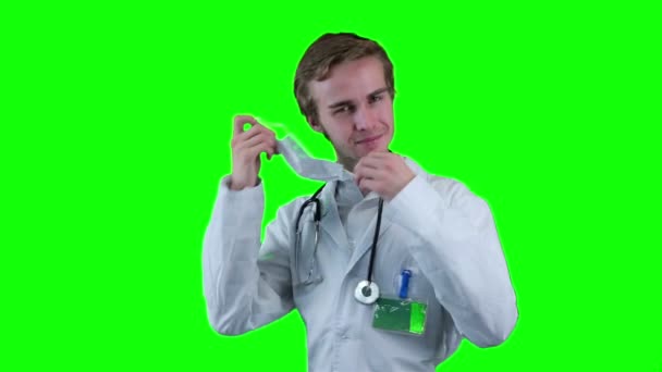 Uśmiechający się lekarz usuwa maseczkę medyczną, patrząc na ekran, daje tabletki. — Wideo stockowe