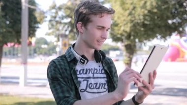Genç adam onun tablet üzerinde haritaya bakıyordum Pokemon Go şehir oynarken.