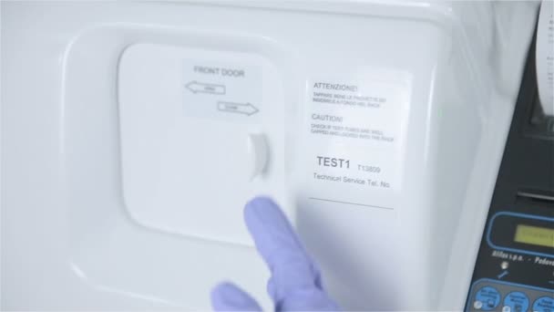 Ärztehände legen Reagenzglas mit Analyse in automatisierte pharmazeutische Labormaschine. — Stockvideo