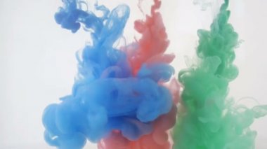 Renkli arka plan. Mavi, kırmızı ve yeşil mürekkep suya düştü. Ağır çekim.