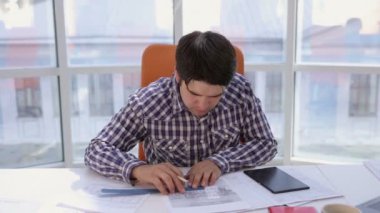 Genç mimar, işadamı modern parlak temiz Office blueprint ve planları ile çalışma.