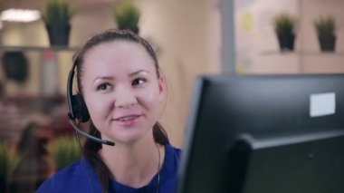 Frendly kadın parlak bir temiz ofis, çağrı merkezi kulaklıktaki söz.