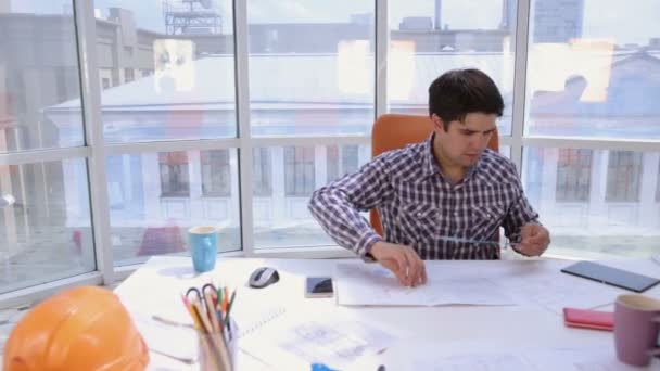 Joven arquitecto, hombre de negocios en moderna oficina limpia brillante trabajando con planos y planos . — Vídeo de stock