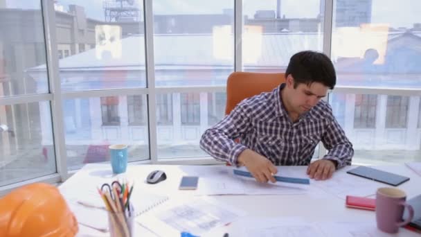 Joven arquitecto, hombre de negocios en moderna oficina limpia brillante trabajando con planos y planos . — Vídeos de Stock