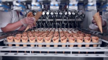 Ice - cream koni ve onları alarak bir işçi ile hareketli bir kemer yakın çekim vurdu. Gıda Sanayi.