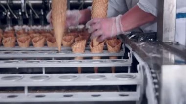 Ice - cream koni ve onları alarak bir işçi ile hareketli bir kemer yakın çekim vurdu. Gıda Sanayi.