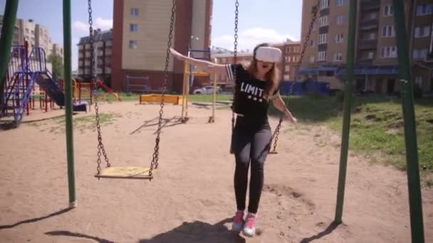 Bonita jovem mulher jogando VR atração balançando ao ar livre. Realidade virtual 3D tecnologia moderna . — Vídeo de Stock