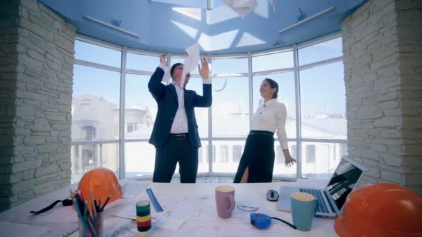 Business people celebrates their success and throws papers up into the air looking at panoramic window in modern office. — Stock Video