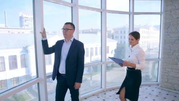Trabajo en equipo. Empresarios discuten proyecto en tableta en oficina brillante limpia cerca de ventana panorámica . — Vídeos de Stock