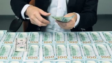 Bir businessmans bize para sayma elleri ve onları masanın üstüne koy. Para arka plan.